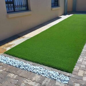 A variety of artificial turf supplies, including adhesive, infill, and seam tape, laying out on a table in preparation for installation.